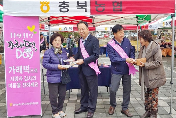 김교선 경제부본부장(왼쪽 두 번째)이 지난 9일 농협 충북본부 금요시장 직거래장터에서 열린 가래떡데이 행사에서 가래떡을 나눠주고 있다.