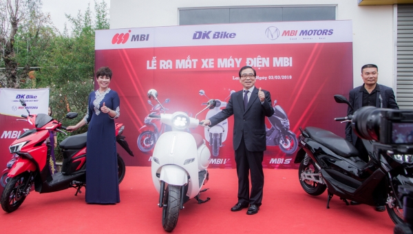 토종 전기오토바이 생산업체 엠비아이 유문수(가운데) 대표가 베트남 DK바이크와 판매 독점계약을 체결한 이후 전시판매장에서 엄지를 들어 올려 보이고 있다.