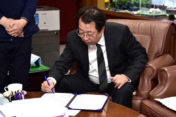 이상천 제천시장이 5일 집무실에서 이마트 제첨점과의 직영 운영점과 관련한 업무협약서에 서명하고 있다.