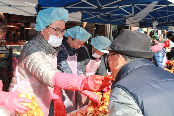 이시종 충북지사가 22일 청주육거리종합시장 입구에서 열린 '사랑의 김장 담그기' 행사에 참여했다. 이 지사가 손수 김장을 담그다가 지나던 행인에게 맛을 보여주고 있다.
