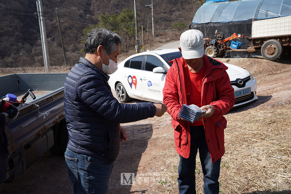 26일 진천군 초평면 용동마을 이장이 코로나19 방역 마스크를 마을 주민들에게 나눠주고 있다.