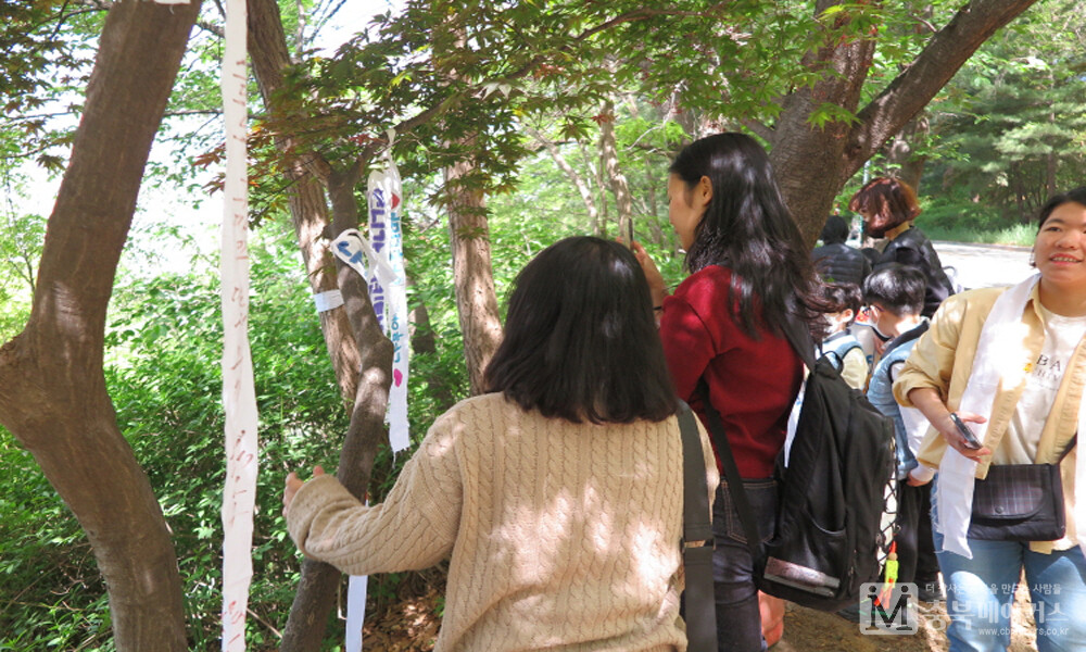 충북시민사회단체연대회의가 지구의 날을 맞아 22일 청주 삼일공원에서 '하늘 다람쥐의 보금자리, 우암산을 지켜주세요' 시민문화제를 개최한 가운데 '데크길이 조성되면 훼손될 위기에 놓인 나무들을 지켜달라'는 나무띠를 아이들이 나무에 달고 있다.