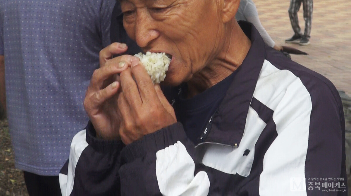 한국자유총연맹 청주시지회가 22일 오전 청주 중앙공원에서 6.25음식체험 및 안보 사진전을 개최한 가운데 한 참가자가 주먹밥을 먹어보고 있다.